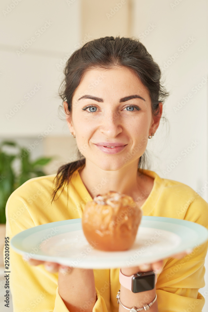 Thanksgiving girl in yellow sweater at home in the kitchen with baked apples Thanksgiving girl in yellow sweater at home in the kitchen with baked apples