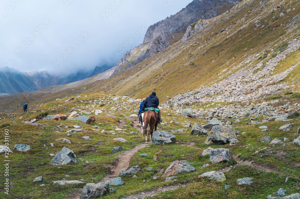 Anonymous people riding horses in the mountains