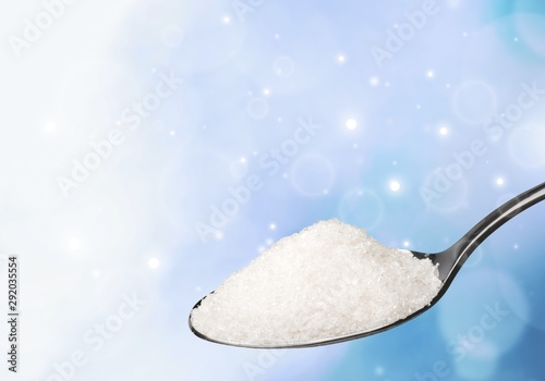 Spoon full of salt on white background