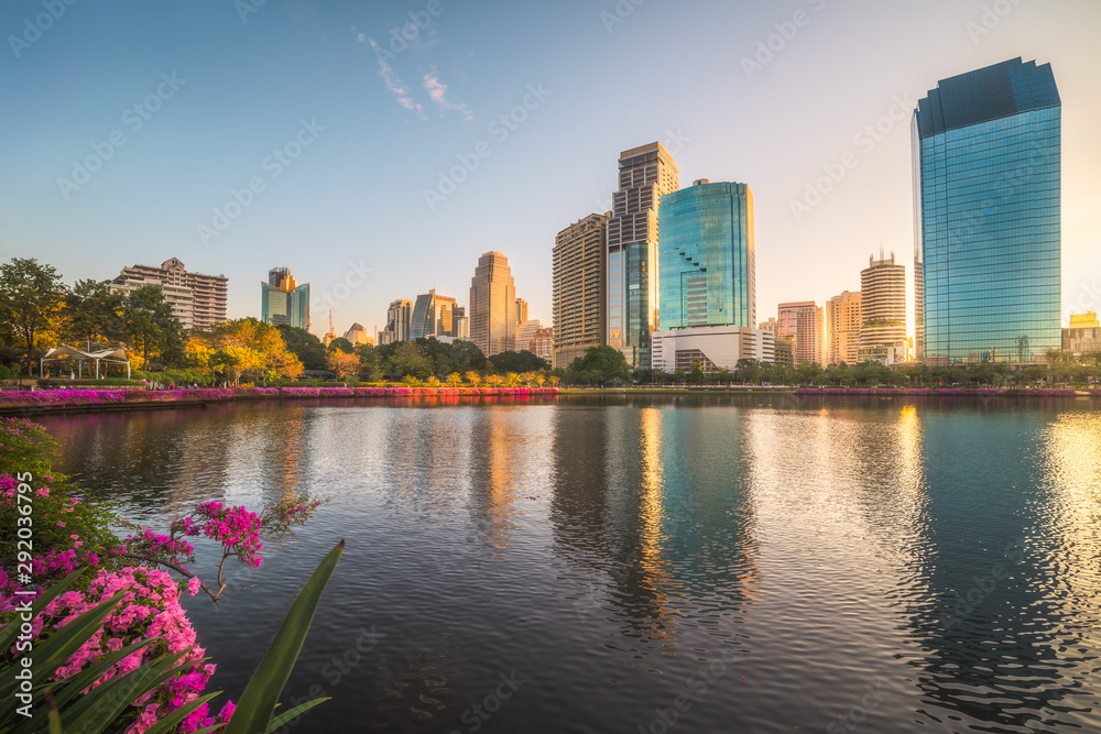Lake with Purple Flowers in City Park under Skyscrapers at Sunrise. Benjakiti Park in Bangkok, Thailand