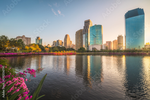 Lake with Purple Flowers in City Park under Skyscrapers at Sunrise. Benjakiti Park in Bangkok  Thailand