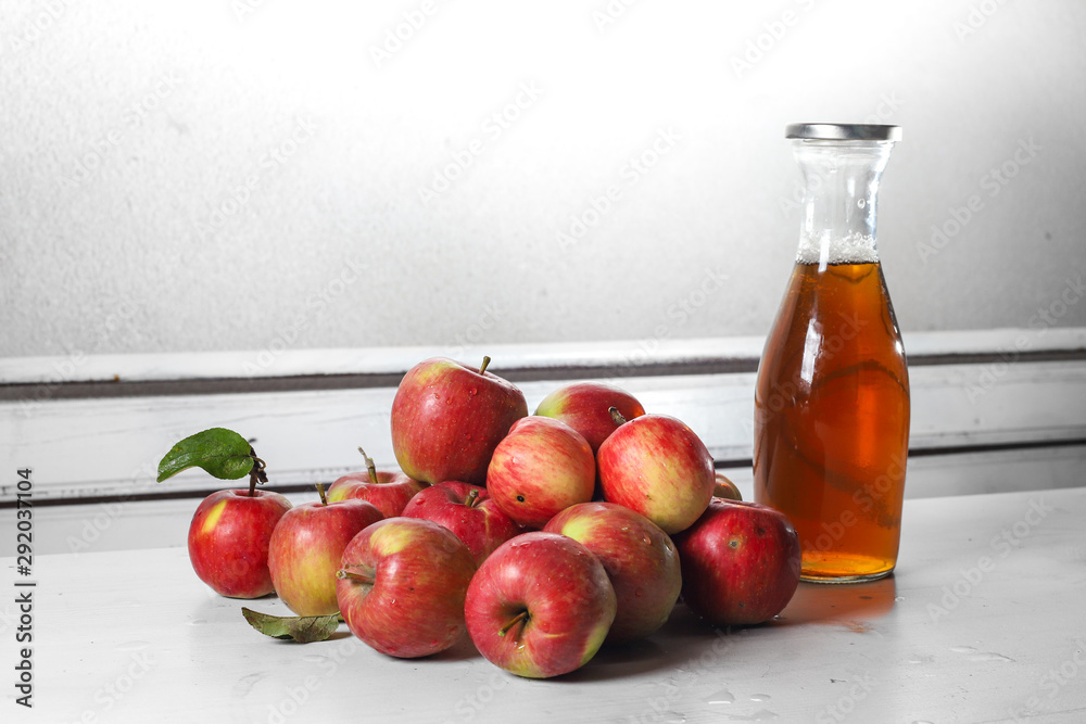 apple juice in glass bottle  and apples on Woden Provence table