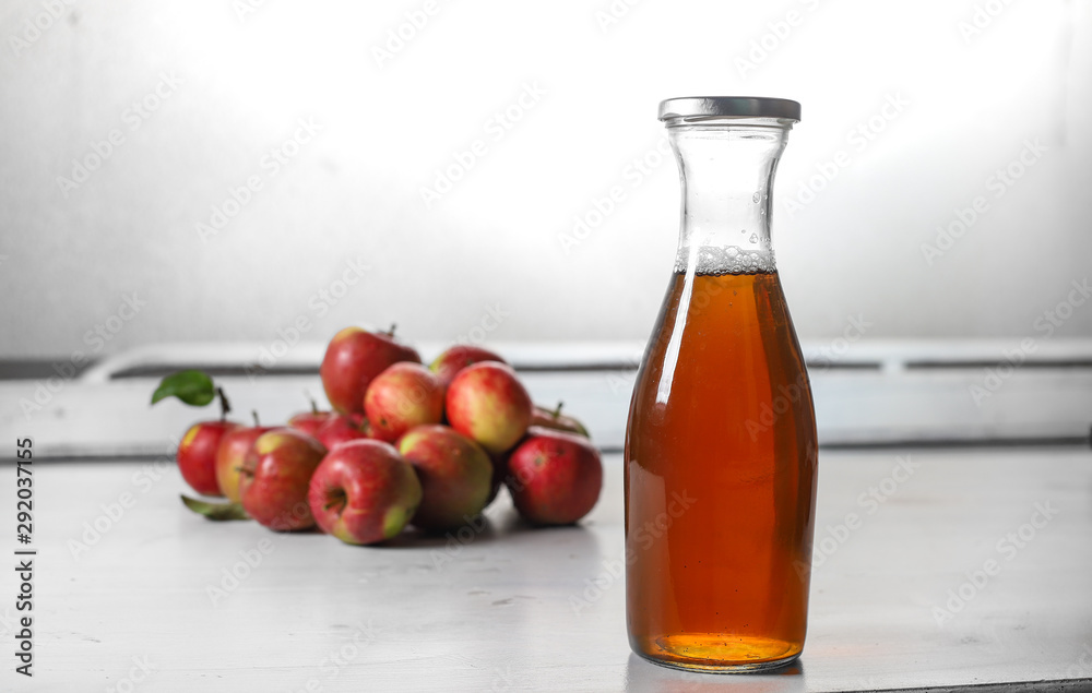 apple juice in glass bottle and apples on Woden Provence table apple juice in glass bottle and apples on Woden Provence table