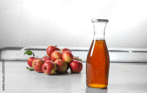 apple juice in glass bottle and apples on Woden Provence table