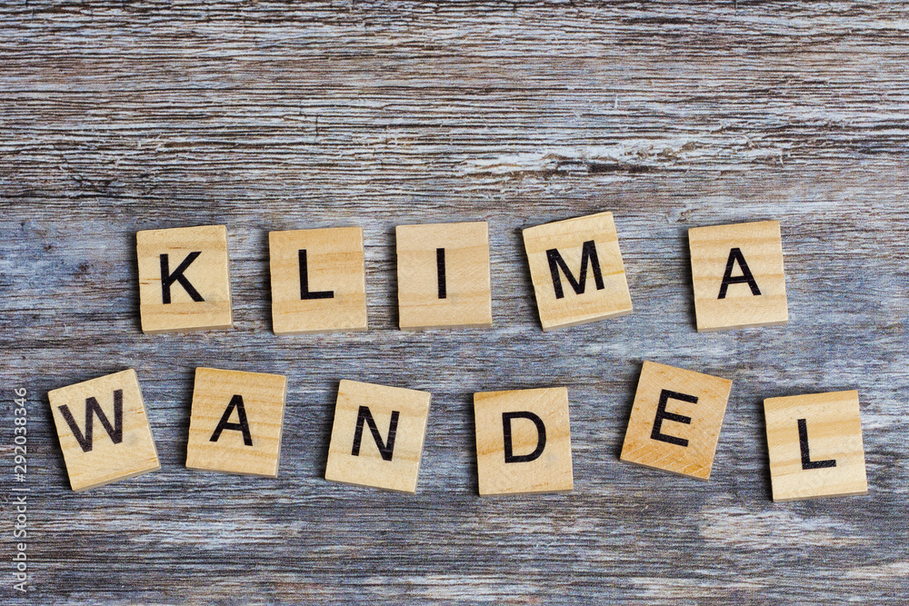 Naklejka premium the German word means climate change in English, laid with wooden capital letters on wooden background