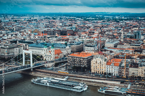 Cityscape of Budapest, Hungary, panoramic top view. Danube river with cruise ships and old town. Landmark famous place. Cloudy weather. Soft focus. Old historic buildings. Travelling to Europe