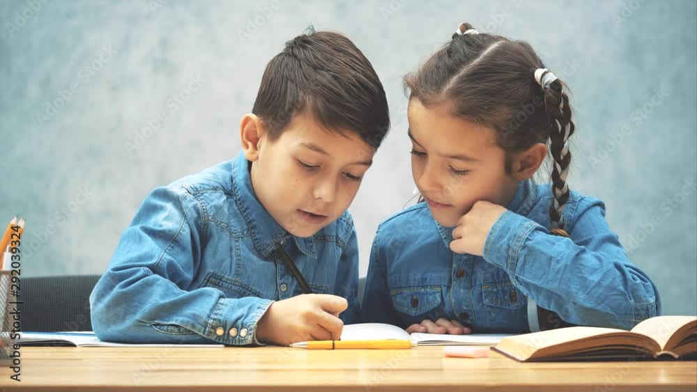 Cute kind brother is helping her sister with her homework. Cute kind brother is helping her sister with her homework.