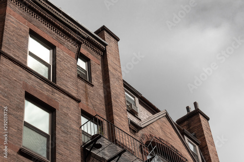 Top edge of old brownstone apartments on a cloudy way, horizontal aspect