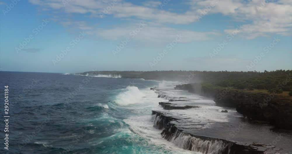 Aerial shot of sea waves are crashing into the rocky cliffs of a desert island before the storm. Aerial shot of sea waves are crashing into the rocky cliffs of a desert island before the storm.