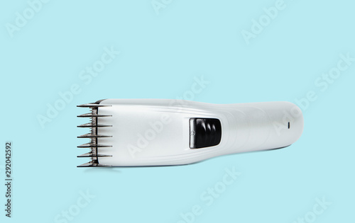 Hair clipper on a pastel blue background. The concept of cutting, improving the appearance. Going to the hairdresser, cutting hair at home. Taking care of appearance.