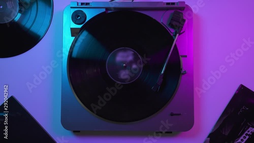 View from top: Vinyl record player on the table in blue and violet neon lights