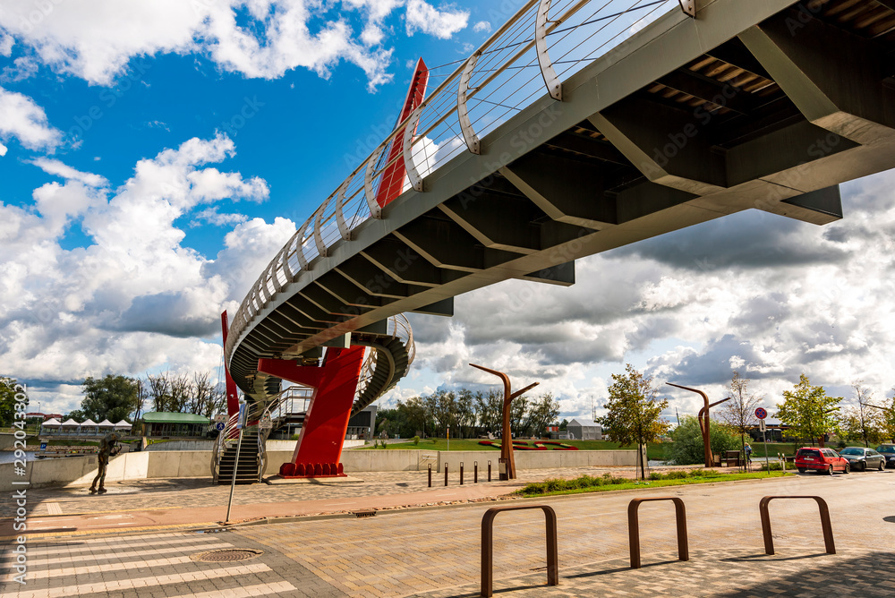 Modern Pedestrian Bridge Mitava over river Driksa in Jelgava, Latvia on a sunny day with blue sky. Modern Pedestrian Bridge Mitava over river Driksa in Jelgava, Latvia on a sunny day with blue sky.