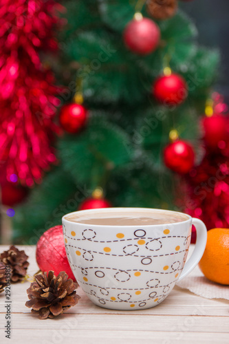 cup of coffee on the background of a festive Christmas tree