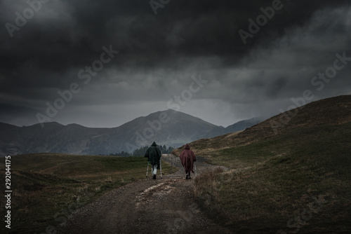 Hikers hiking in Alpe di Siusi - Seiser Alm with dramatic sky
