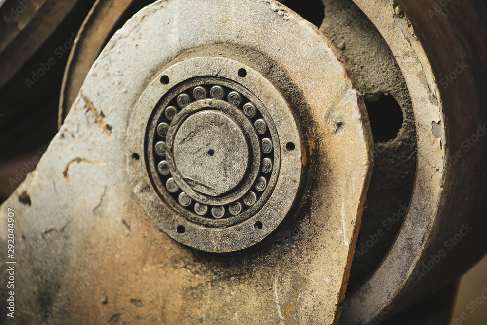 Details with an industrial metal bearing in a dirty and old but still functioning metal works, old fashioned, factory Details with an industrial metal bearing in a dirty and old but still functioning metal works, old fashioned, factory