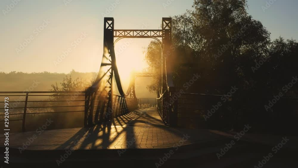 The red metal bridge over a small river on the embankment of the city of Irpin in Ukraine, low slow drone flight