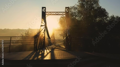 The red metal bridge over a small river on the embankment of the city of Irpin in Ukraine, low slow drone flight
