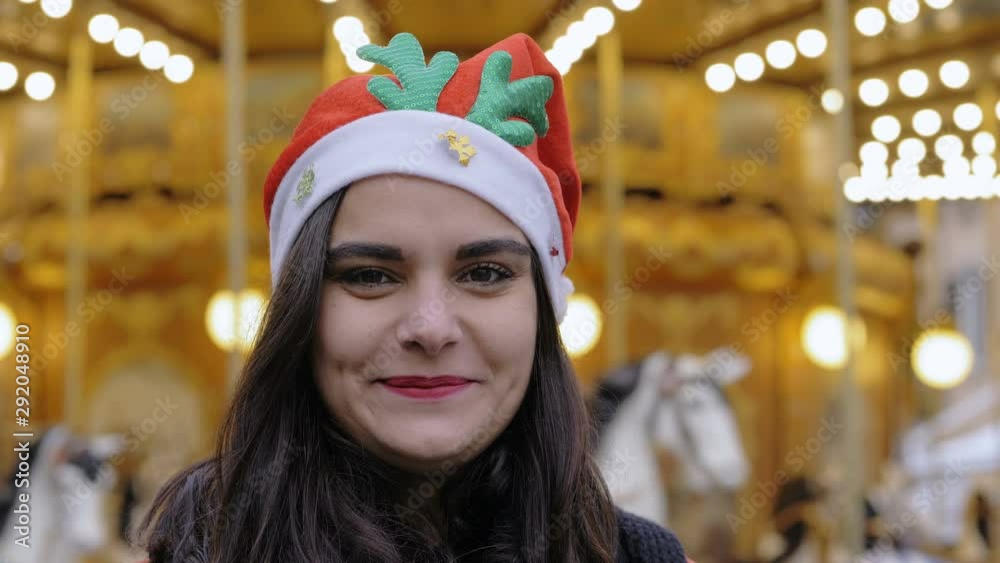 Young happy woman with Christmas hat smiling at camera. Concept of holidays Young happy woman with Christmas hat smiling at camera. Concept of holidays