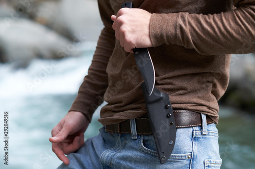 Εκτύπωση καμβά Man holding a tactical survival knife in the ready position outdoors in the wilderness