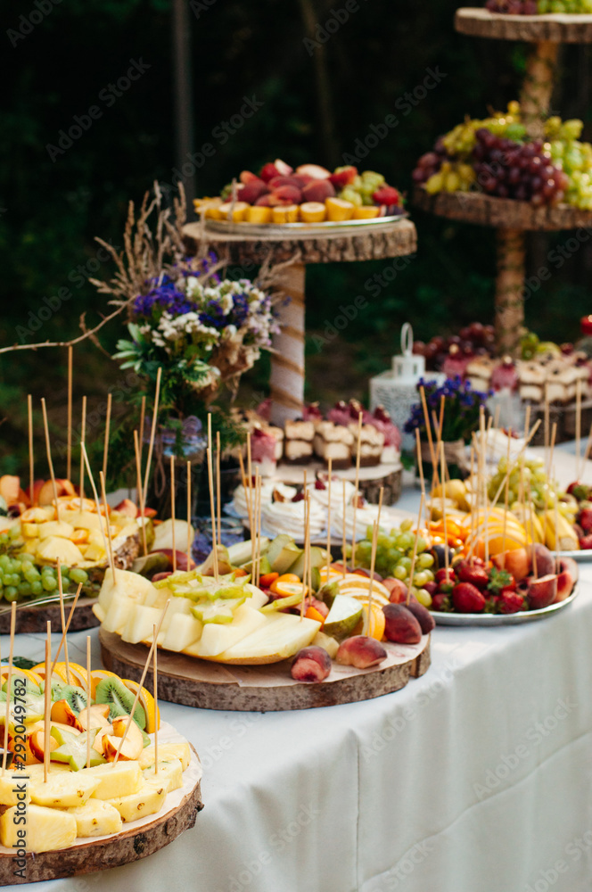 Beautiful wedding candy bar with a lot of  sweets, fruits and food. Wedding banquet table