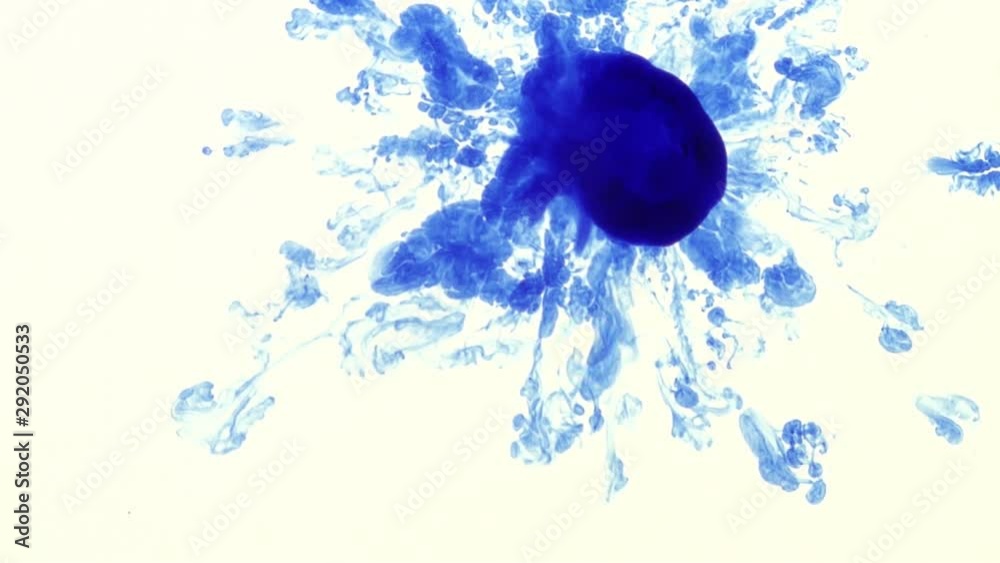 A drop of blue ink is dropped into a laboratory glass petri dish and drifting in abstract shapes. Slow motion clip, shot from below the dish.