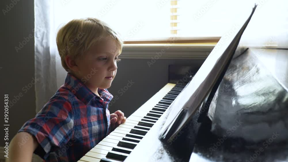 Young boy learns how to play the piano