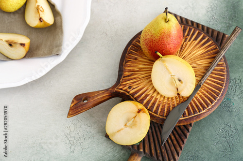 Boards with tasty fresh pears and knife on table