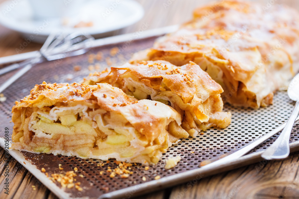 Frisch gebackener Apfelstrudel mit puderzucker auf einem backblech Frisch gebackener Apfelstrudel mit puderzucker auf einem backblech