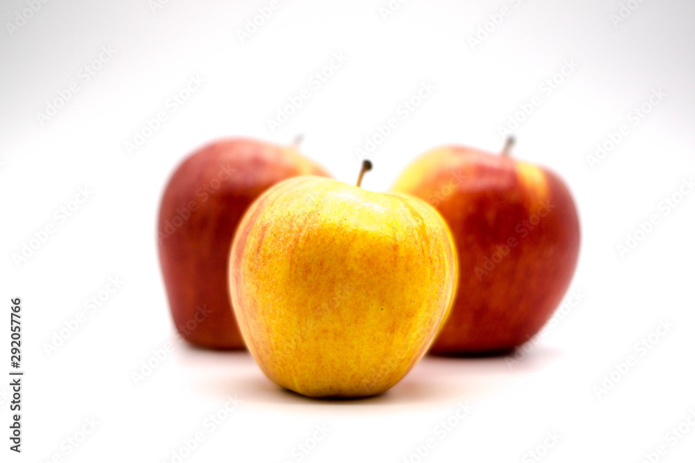 yellow apple front and center of red apples yellow apple front and center of red apples