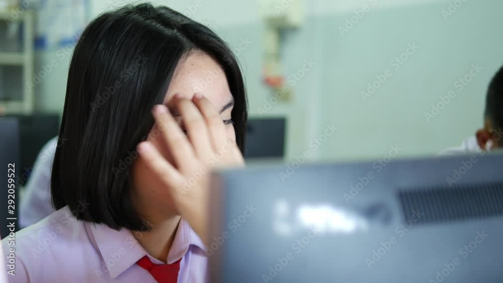 Asian female high school student in white uniform is studying in computer room. Asian female high school student in white uniform is studying in computer room.
