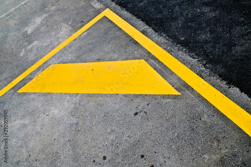 Abstract fragment of yellow road signage - parking lot markings on black road surface. © Daguimagery
