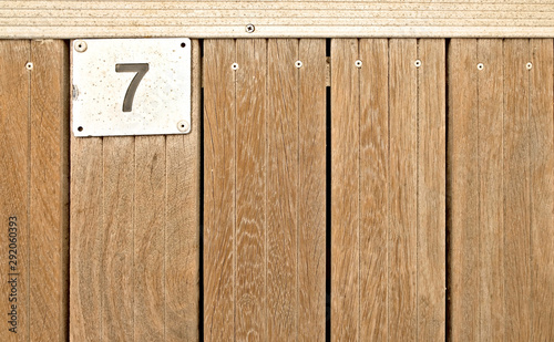 7, number seven, metal plate on wooden teak deck. photo