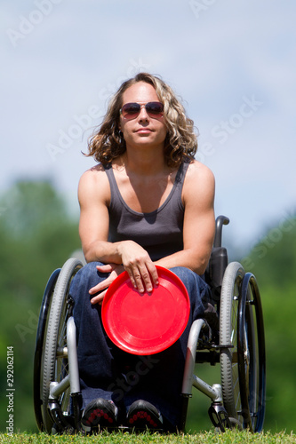 Woman in wheelchair playing catch at park