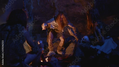 Wallpaper Mural In earliest human family tribe leader teaching hunting skills telling stories and earing meat on fire. Ancient primitive people. Homo sapiens. Torontodigital.ca