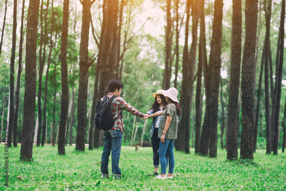 Closeup image of travelers putting their hands together in the forest Closeup image of travelers putting their hands together in the forest