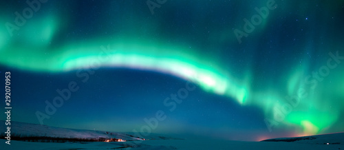 Fototapeta Naklejka Na Ścianę i Meble -  active glowing green aurora borealis in the winter night sky over the plain snow field; banner size 