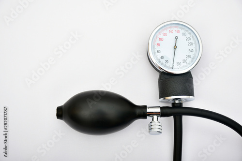 Tensiómetro esfingomanómetro negro en cruz fondo blanco