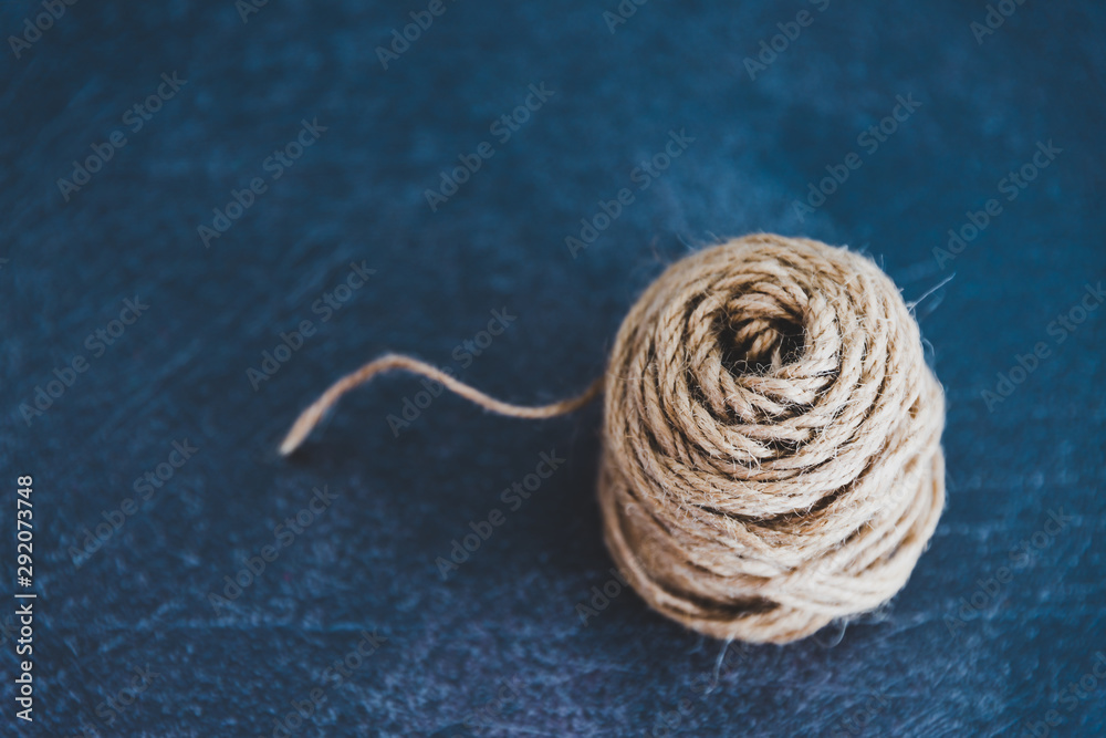 tangled ball of thread with string popping out of it