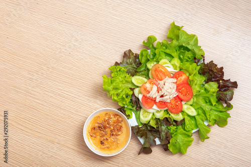 many vegetables with chicken salad and lalad sauce on wood background with copy space
