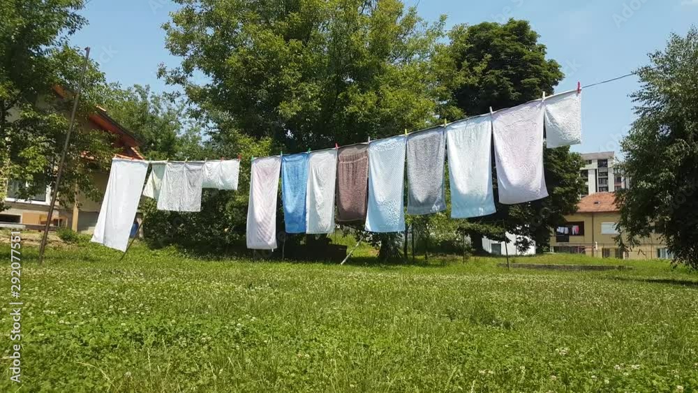 Towels pinned to a line in the backyard to wind dry over the grass