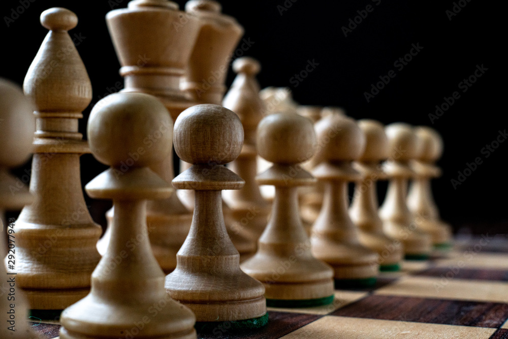 macro shot of the chess pieces on the board on dark background