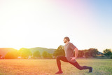 Sports and yoga. A man with a beard, in sportswear squats during a workout. Light and copy space