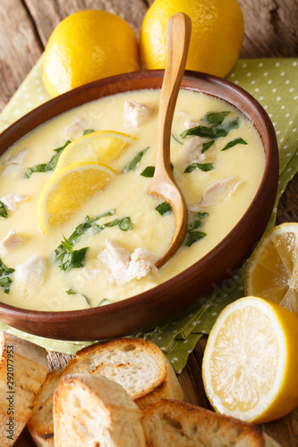 Greek lemon soup Avgolemono served with toasted bread close-up in a bowl. vertical