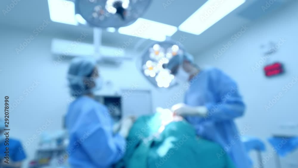 Blur of surgeons team working with monitoring of patient in surgical operating room Blur of surgeons team working with monitoring of patient in surgical operating room