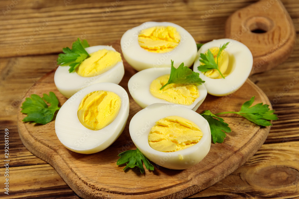 Boiled eggs with parsley on cutting board on a wooden table Boiled eggs with parsley on cutting board on a wooden table