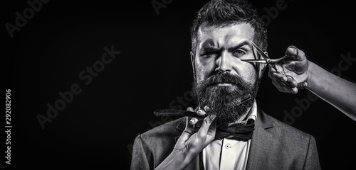 Barber scissors and straight razor, barber shop. Copy space. Beard care. Bearded client visiting barber shop. Vintage barbershop, shaving. Bearded man, bearded male. Black and white