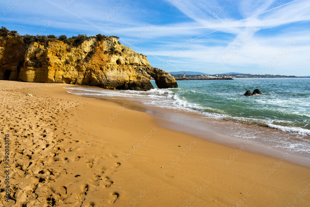 Scenic view of Batata beach (Praia da Batata) with with typical golden cliffs e footprints on the sand, Lagos, Algarve, Portugal