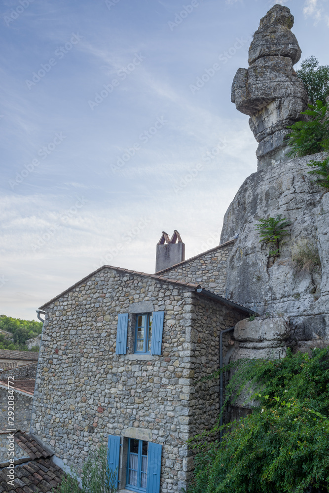 Stone house in the village of Labeaume overcome of a rocky peak, Ardèche, France.