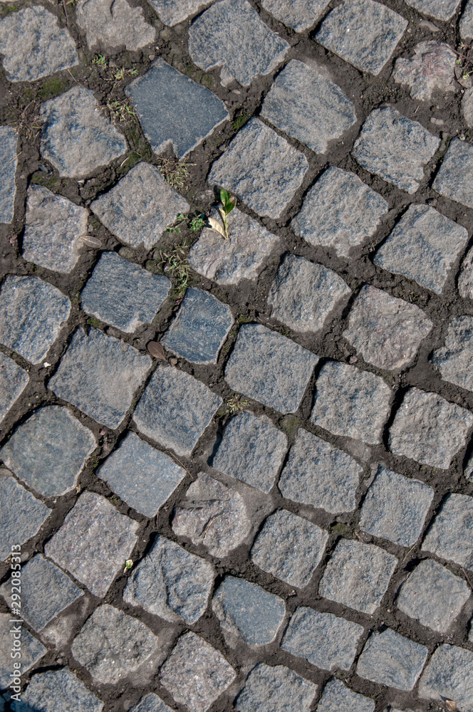 The road is lined with large gray stones. Grey background. The road is lined with large gray stones. Grey background.