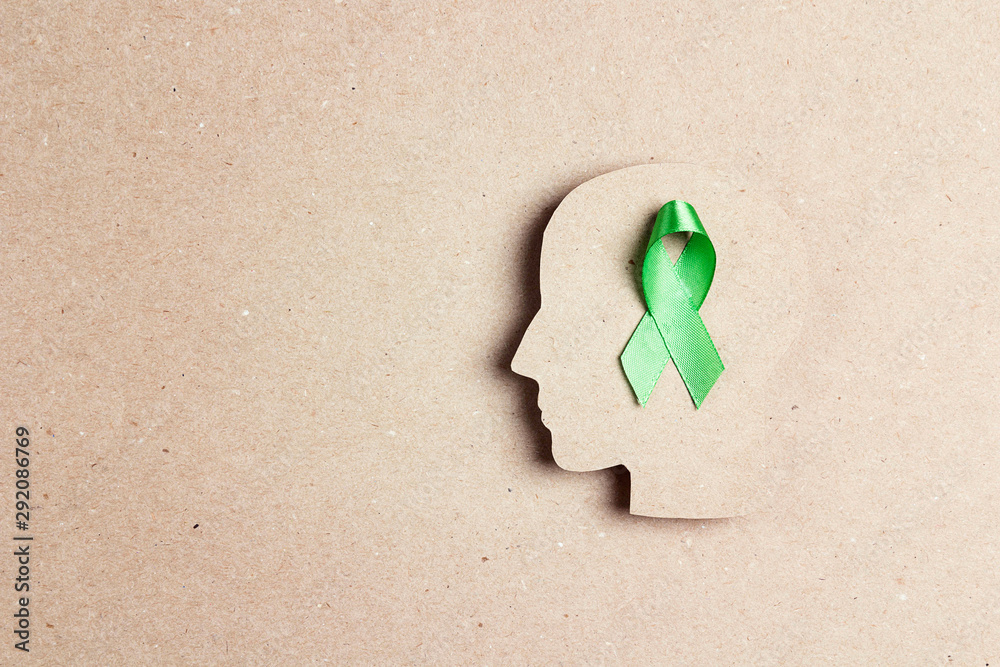 World mental health day concept. Green awareness ribbon with brain ...